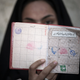 A woman holds her identification in front of her face as she rests after voting at a polling station during Iran’s parliamentary election in southern Tehran March 2, 2012.